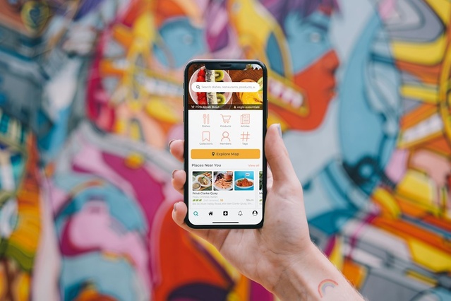 Hand holding a phone showing a mobile app